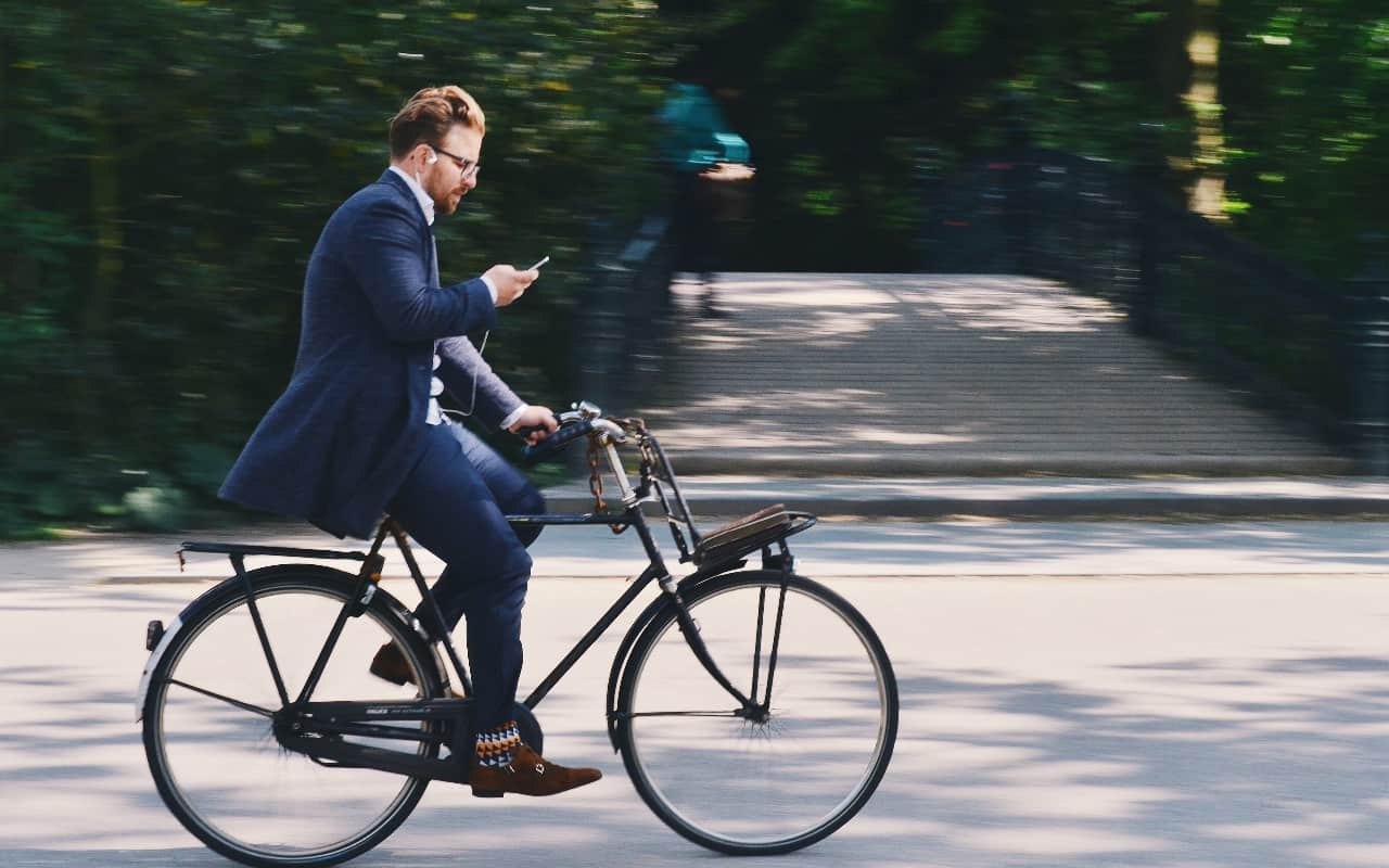 guy bike in a suit amsterdam